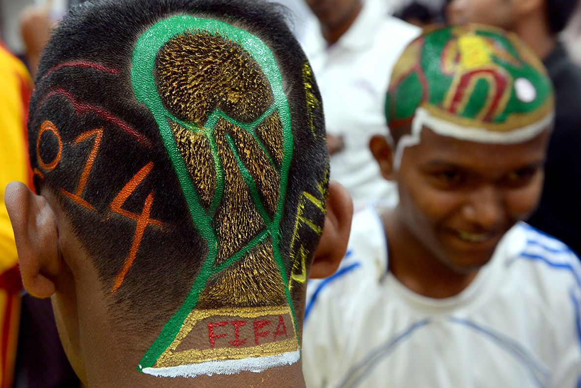 Football enthusiasts Nilesh Kadam (L) and Abhijit Chavan have World Cup-inspired scenes shaved and painted onto their heads at a salon in Mumbai.