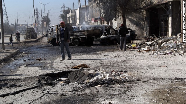 A man stands next to debris in the road following a reported airstrike by Syrian government forces in Aleppo on February 8.
