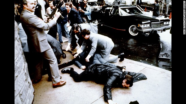 Police and Secret Service agents react during the Reagan assassination attempt, which took place March 30, 1981, after a conference outside the Hilton Hotel in Washington. Lying on the ground in front is wounded police officer Thomas Delahanty. Brady is behind him, also lying face down.