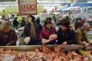 Customers select pork products under a price tag at a supermarket in Hangzhou