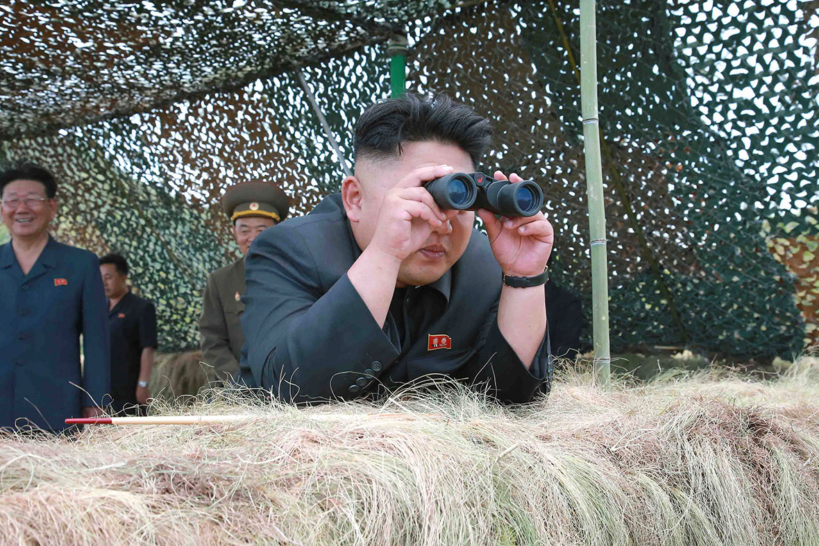 North Korean leader Kim Jong-un uses binoculars as he guides a live-firing exercise