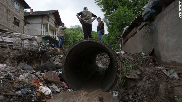 People work to clear debris from a small stream that was clogged and causing localized flooding near their homes in Tuzla, Bosnia, on Sunday, May 12.