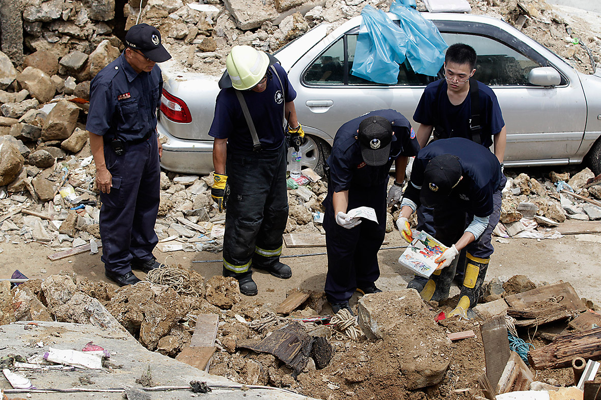 Rescue personnel sort through belongings found in the wreckage