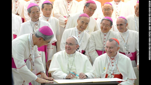 Pope Francis laughs with bishops as he signs a guestbook Thursday, August 14, at the headquarters of the Korean Episcopal Conference in Seoul, South Korea. The Pope's trip to South Korea marks the first papal visit to the country since Pope John Paul II visited 25 years ago.