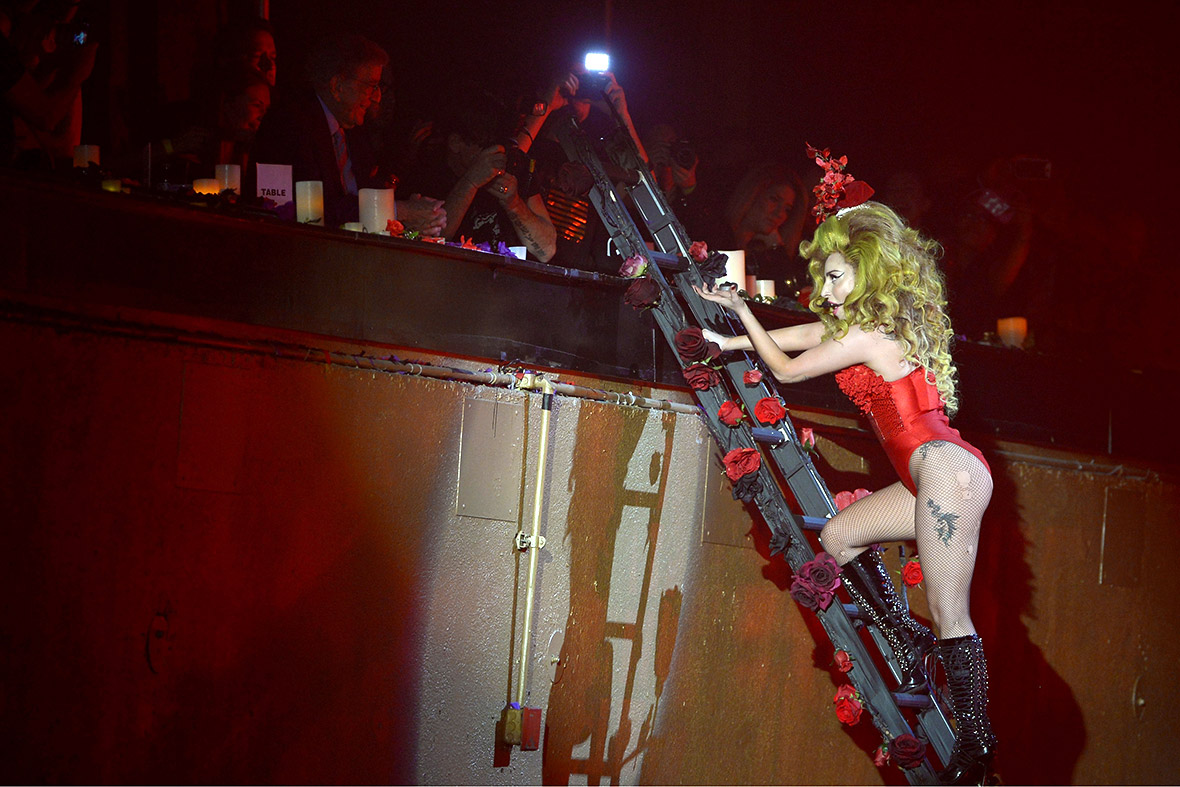 Lady Gaga climbs a ladder to reach the balcony...