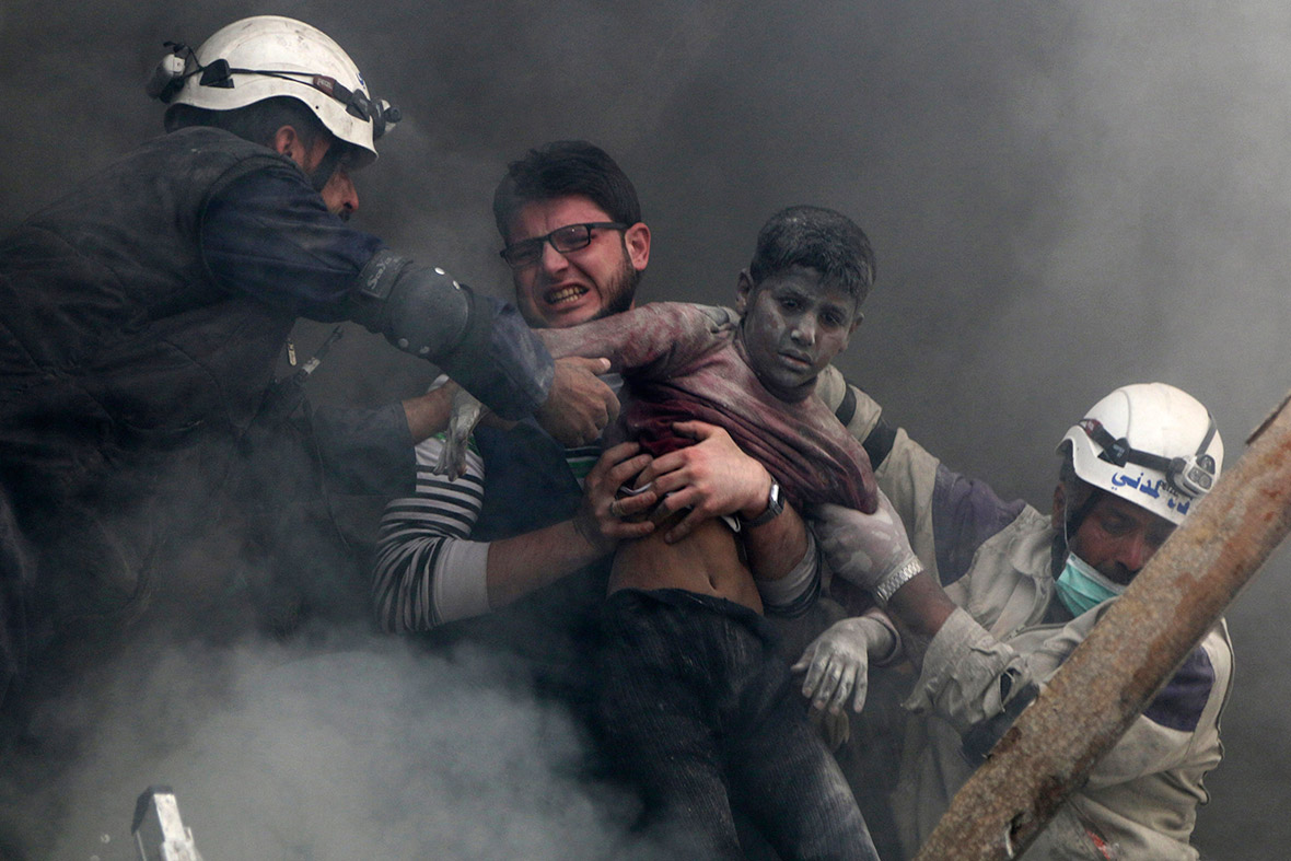 Men rescue a boy from under the rubble of a building after what activists said was a barrel bomb attack by forces loyal to Syria's President Bashar Al-Assad in Al-Shaar neighbourhood of Aleppo