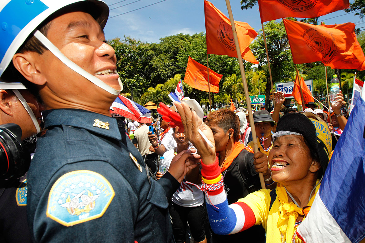 An anti-government protester jokes with a military officer during a rally at an Air Force base in Bangkok.