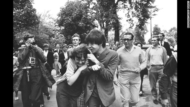 McCartney is hugged by an adoring fan after arriving at rehearsal for the TV show "Jukebox Jury" in London in 1964.