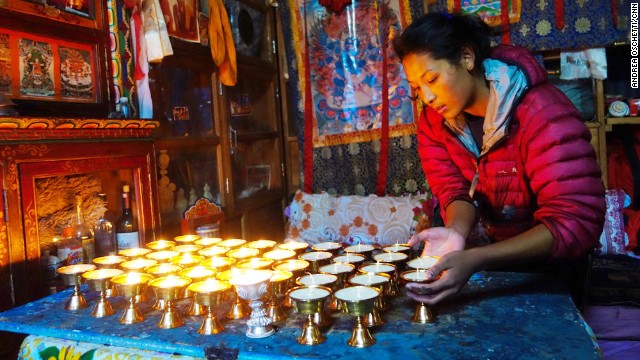 Butter lamps must remain lit throughout the 49-day period between lives (Bar-do), at the end of which the spirit of the deceased will reincarnate. The daughter of Ang Tshiring, Nima, attends to the butter lamps in the prayer room.