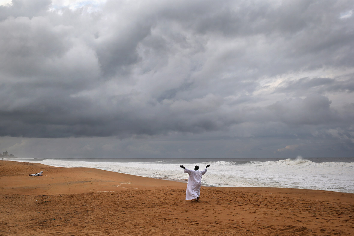A member of the Church of Aladura prays for God to rescue Liberia from Ebola, on the beach in Monrovia