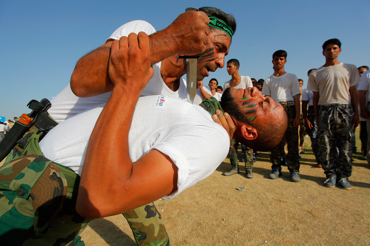 Shi'ite volunteers, who have joined the Iraqi army to fight against Isis, demonstrate their skills during a graduation ceremony after completing their field training in Najaf