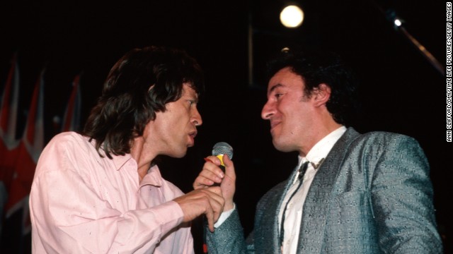 Mick Jagger and Bruce Springsteen share a microphone during the Beatles' induction into the Rock and Roll Hall of Fame in 1988.