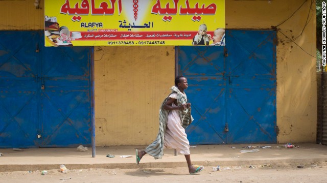 A woman runs through the street in Malakal as gunshots ring out a few streets over on January 21.