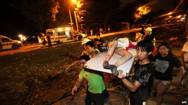 Residents carry a wounded person following a blast in the city of Kaohsiung