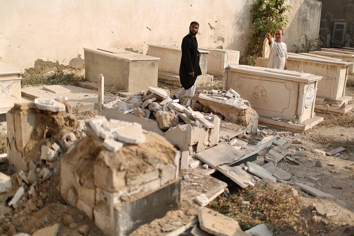Palestinians inspect a cemetery damaged during Israeli shelling, in Gaza City