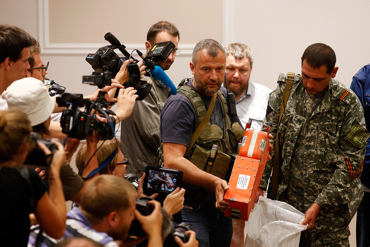 A pro-Russian separatist shows members of the media a black box said to belong to Malaysia Airlines flight MH17, before handing it over to Malaysian representatives, in Donetsk, Ukraine