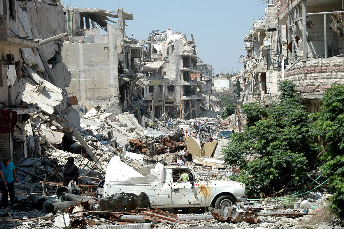 People look through the debris as they return to the Juret al-Shayah district