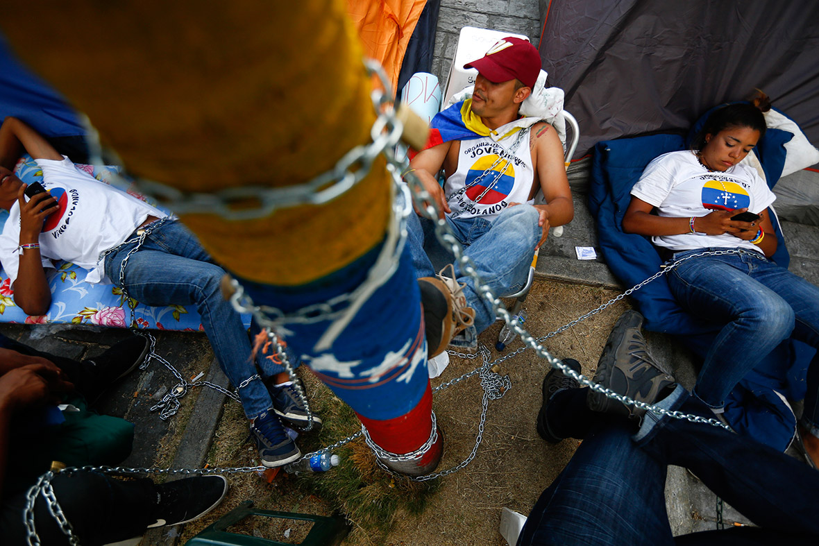 Anti-government protesters chain themselves to UN offices in Caracas, Venezuela.