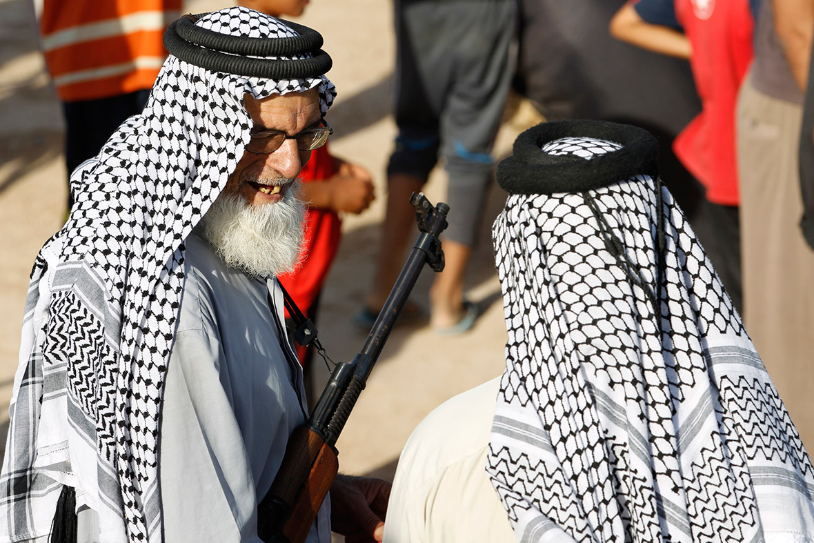 An elderly volunteer holds a weapon during a parade in the streets of Baghdad.