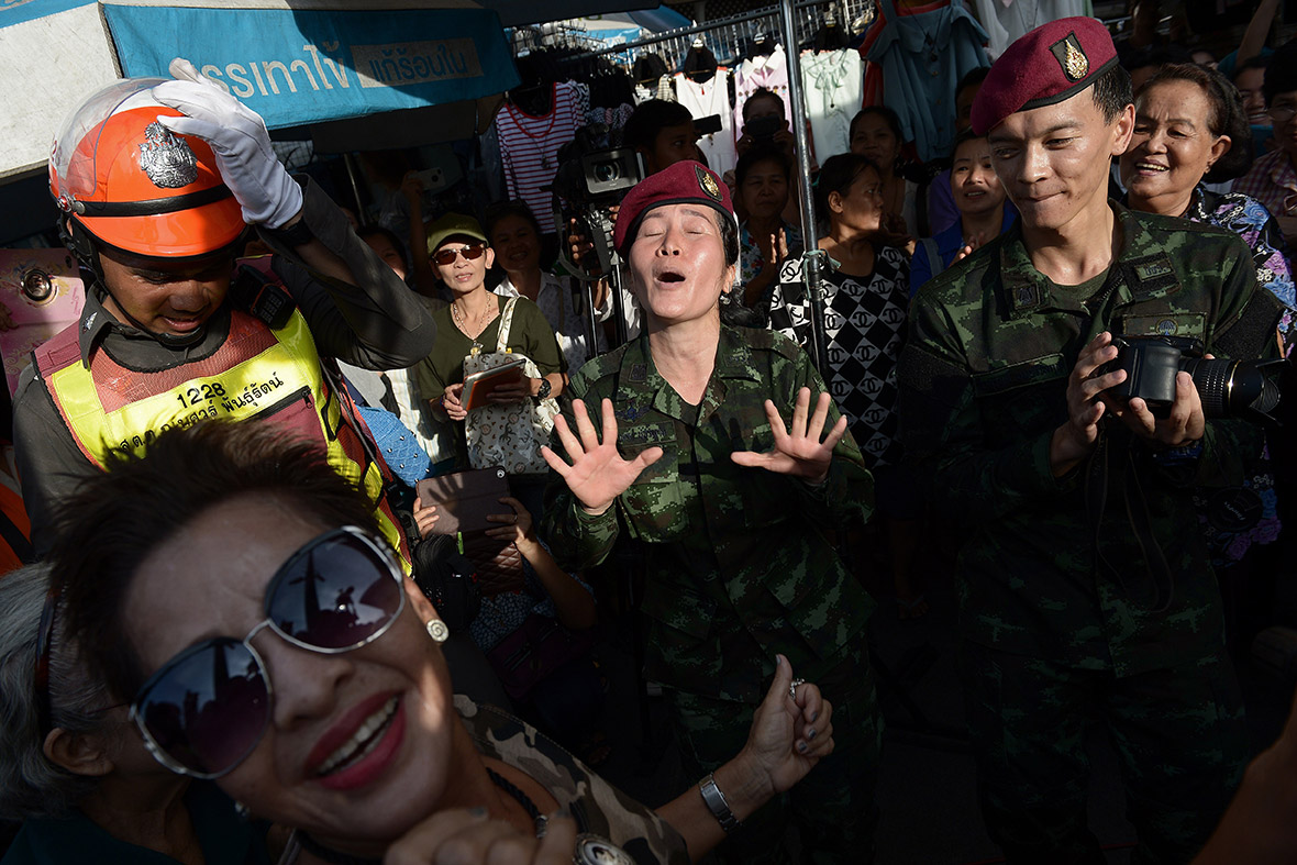Thai soldiers dance with residents at a military event organised to 'return happiness to the people' at Victory Monument, the site of recent anti-coup rallies in Bangkok