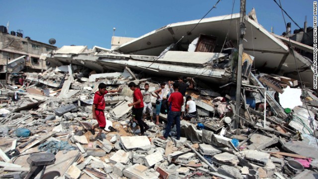 Palestinians inspect destroyed buildings and collect usable items after an Israeli air assault on July 22. 