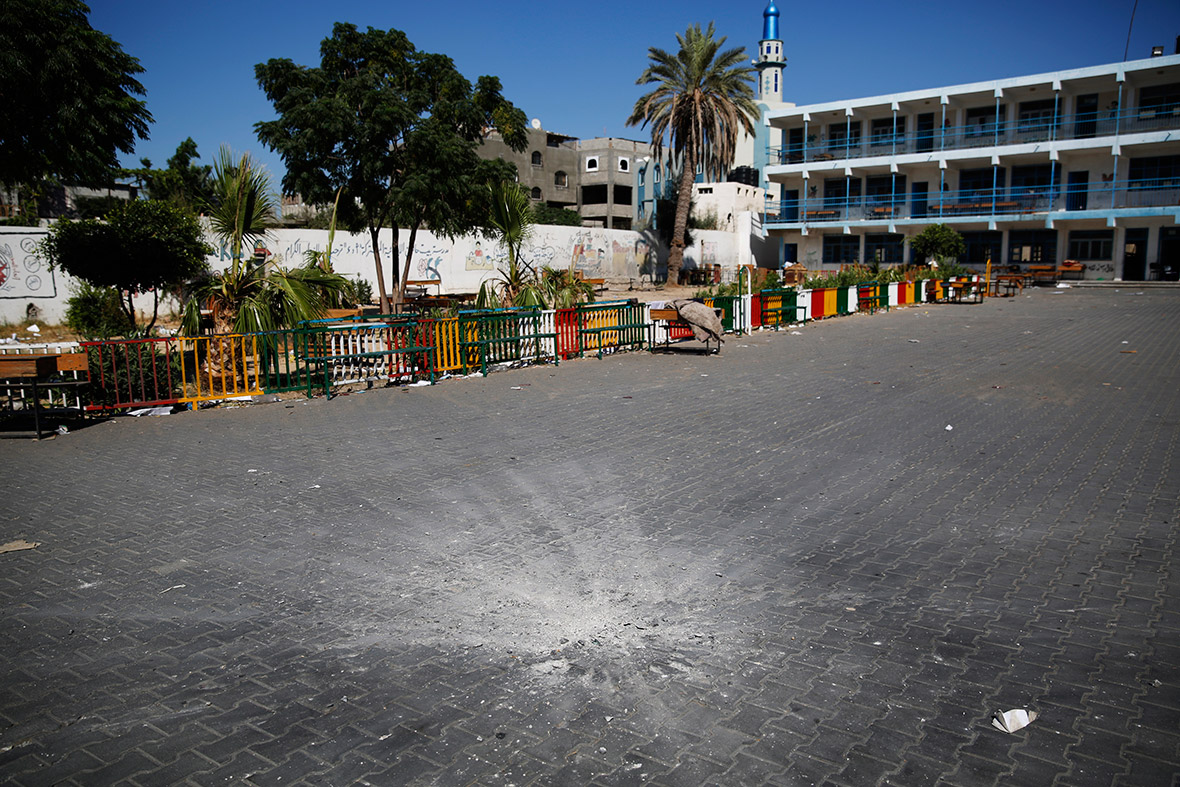 A crater is seen in a courtyard after a United Nations-run school sheltering Palestinians was hit by an Israeli shell