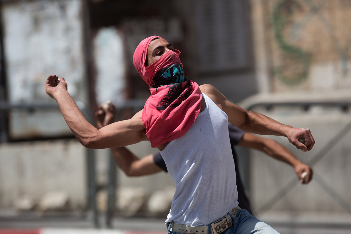 Palestinians throw stones towards Israeli forces during clashes in the West Bank town of Hebron.