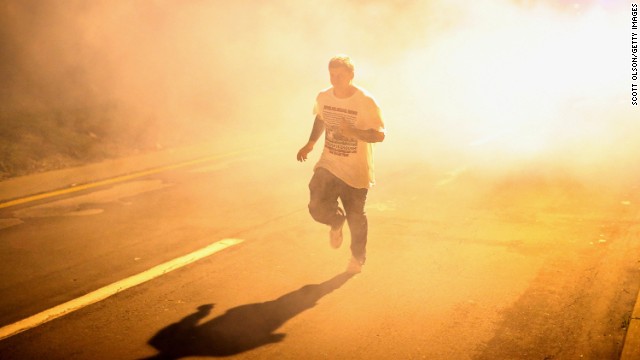 A man runs through clouds of tear gas on August 17.