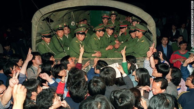 May 20, 1989, pro-democracy demonstrators raise their fists and flash the victory sign while stopping a military truck filled with soldiers on its way to Tiananmen Square.