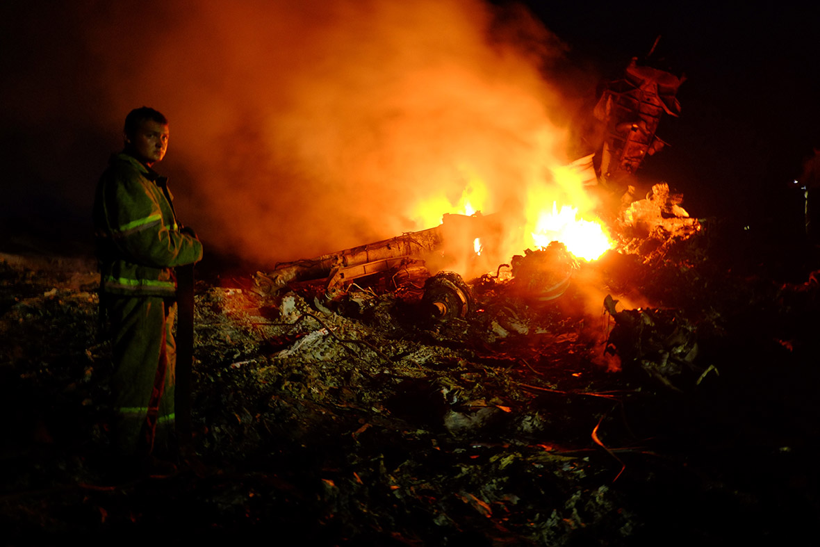 A firefighter stands among the burning wreckage of the Malaysian airliner.