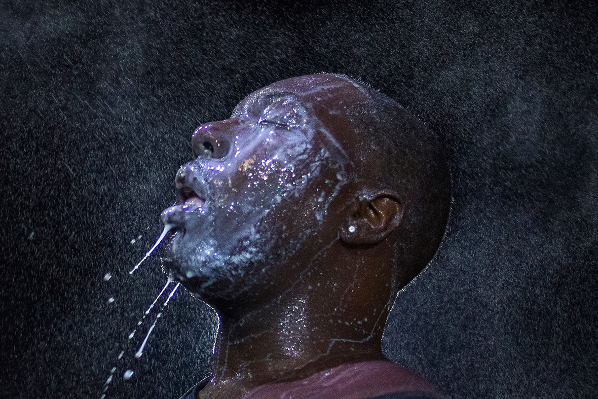 A man is doused with milk and sprayed with mist after tear gas was fired by security forces trying to disperse demonstrators protesting against the shooting of unarmed black teen Michael Brown in Ferguson, Missouri