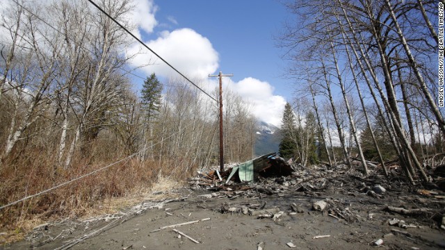 Downed power lines and parts of a destroyed house can be seen in the debris blocking the road near Oso on March 23.
