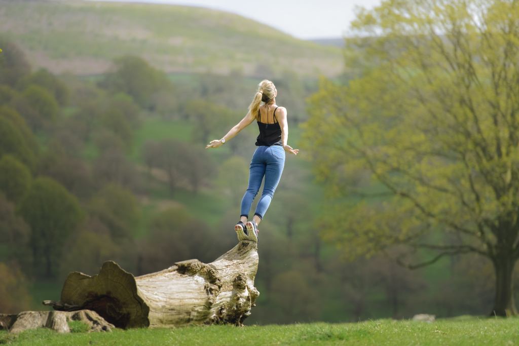 Woman Gracefully Falling & Jumping Of Tree In Field