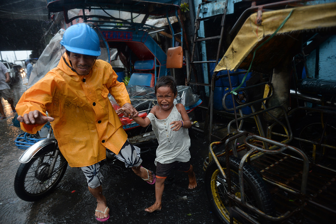An official leads a child as he is evacuated from a house at an informal settlers' area in Manila.
