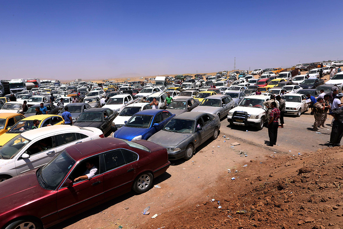Iraqis fleeing violence in Nineveh province wait in their vehicles at a checkpoint in Aski kalak after suspected jihadists seized the province and its capital Mosul.