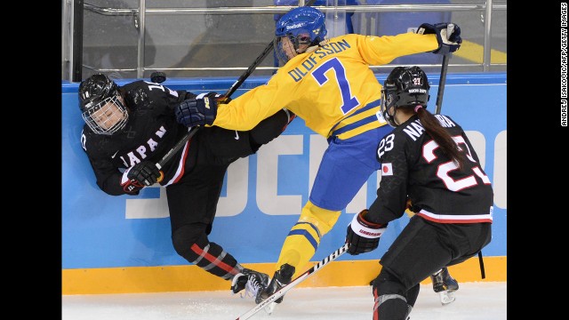 Sweden's Johanna Olofsson, center, vies with Japan's Haruna Yoneyama, left, during their Group B hockey game February 9.