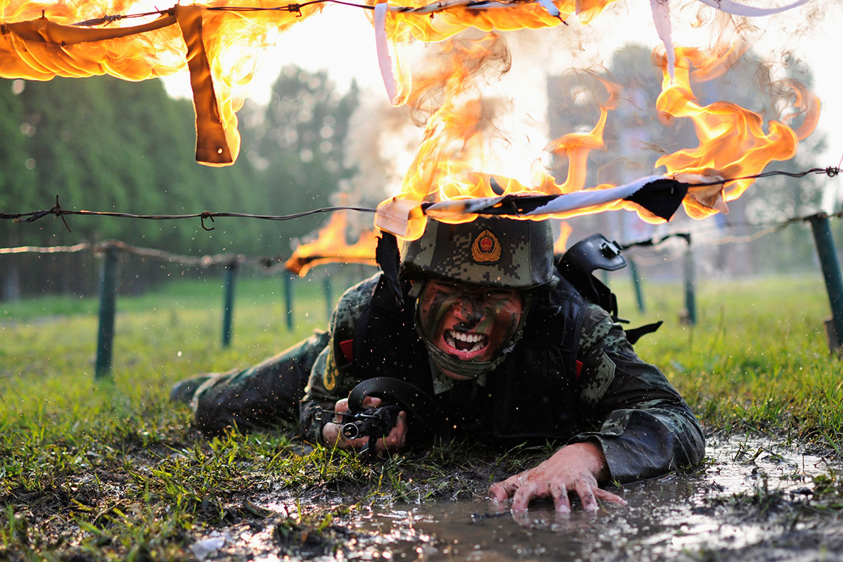 A paramilitary policeman crawls under obstacles during a drill at a military base in Chaohu, Anhui province, China.