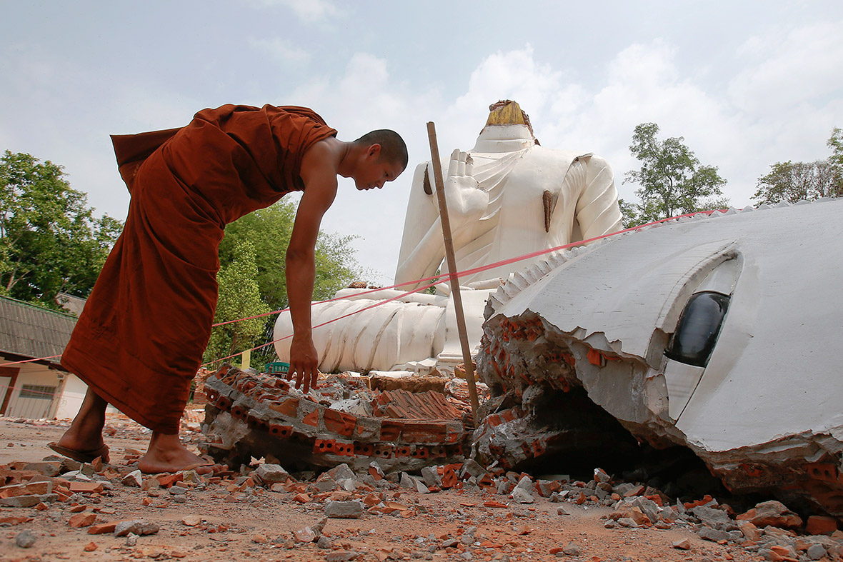 A Buddhist monk checks a statue that was damaged by an earthquake at the Udomwaree temple in Chiang Rai, in northern Thailand.