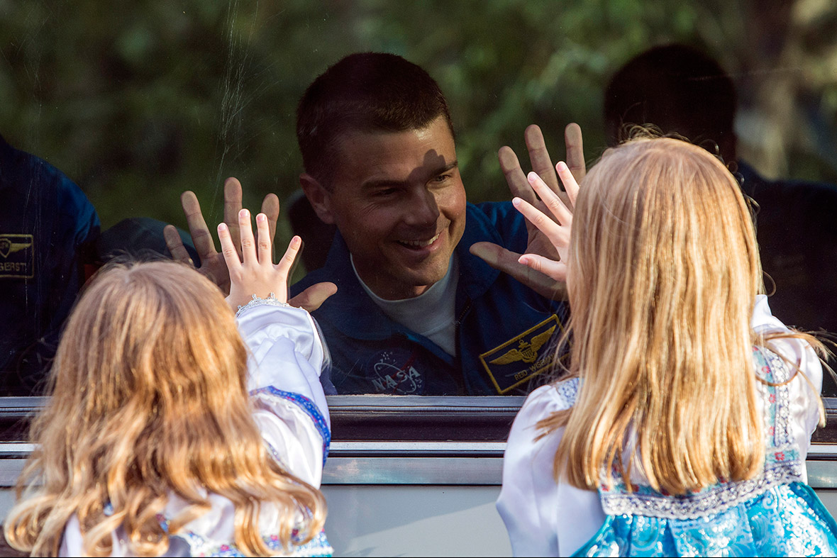 Reid Wiseman of the US, a member of the International Space Station crew, waves to his daughters from a bus before departure for a final pre-launch preparation at the Baikonur cosmodrome