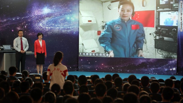 A girl in a school in Beijing asks Chinese female astrounaut Wang Yaping questions as Wang delivers a lesson to students from Tiangong-1 space module on June 20, 2013. 