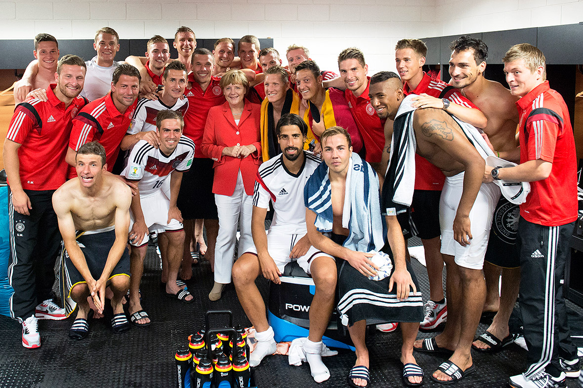 Chancellor Angela Merkel visits the German national team in their dressing room after they beat Portugal at Arena Fonte Nova in Salvador, Brazil