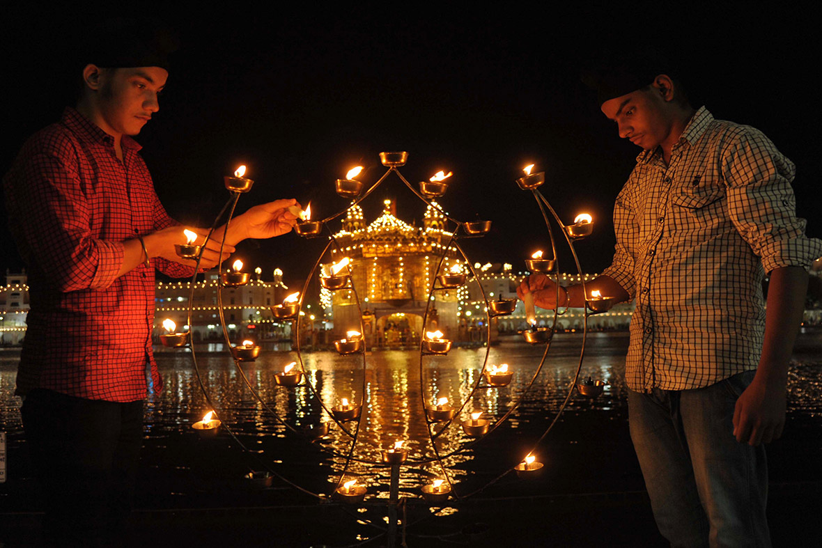 Indian Sikh devotees light lamps at the Golden Temple in Amritsar.
