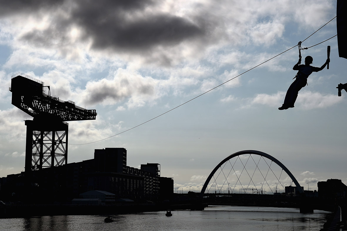 Nina Saunders makes her way across a zip wire over the river Clyde from the Finnieston Crane in Glasgow, carrying the Commonwealth Games baton