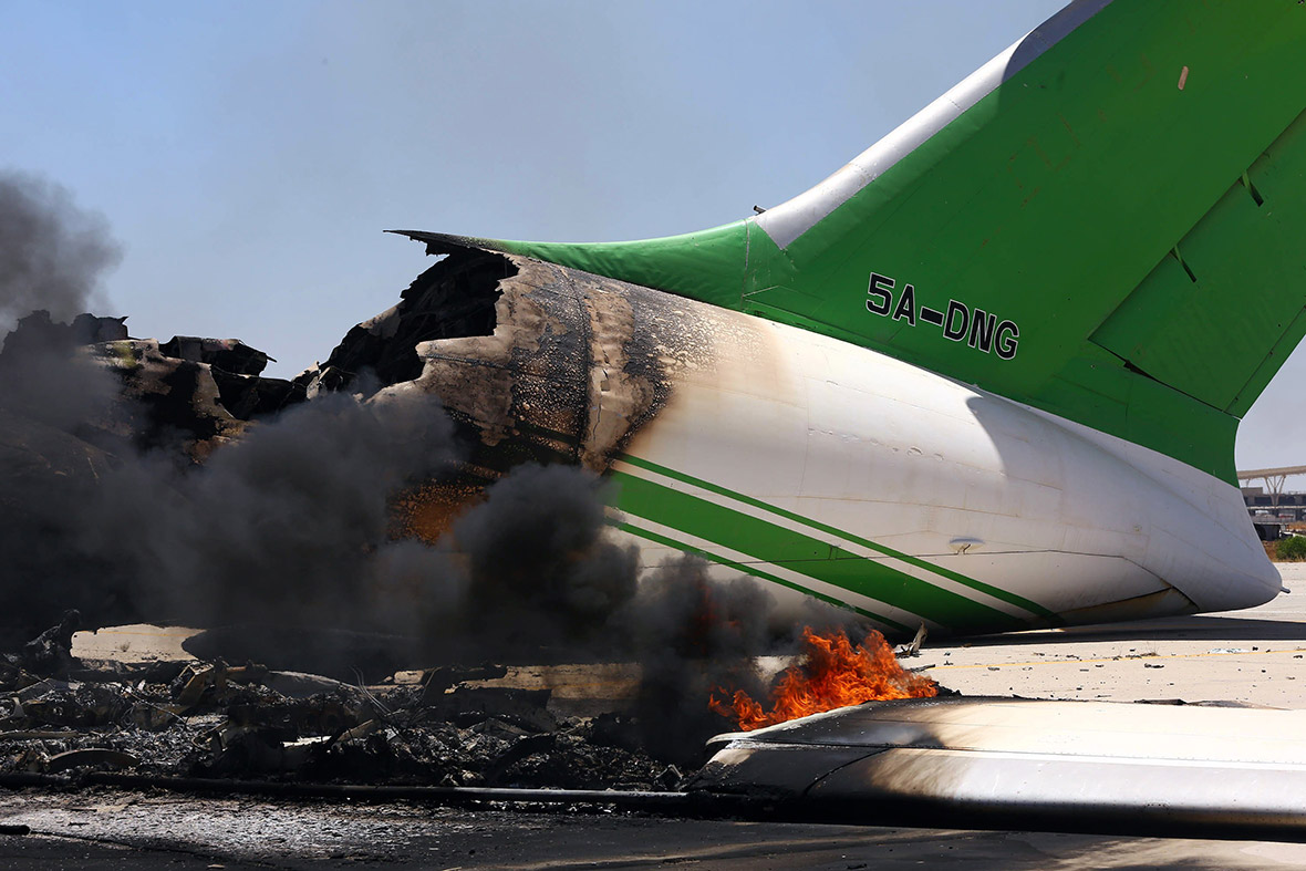 July 16, 2014: Flames and smoke billow from a plane on the tarmac at Tripoli international airport. Islamist militias have fired dozens of rockets at Tripoli airport, damaging planes and closing down Libya's main air link with the outside world