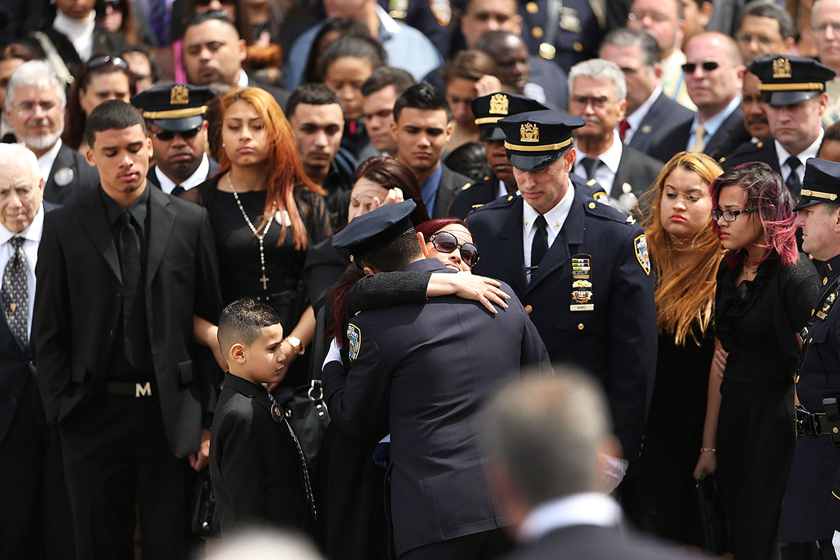 Dennis Guerra's wife, Cathy, hugs a police officer during the funeral for the fallen officer in New York City. Guerra died last week from injuries suffered in an arson blaze at a Coney Island public housing apartment building. Guerra's patrol partner, Rosa Rodriguez, remains in a critical condition. Felony murder charges were brought against Marcell Dockery, 16, who confessed that he set a mattress on fire because he was bored