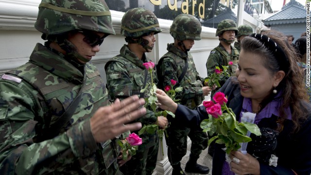 Thai soldiers receive roses from coup supporters at a military base in Bangkok on May 27. Since taking power, military authorities have summoned -- and in some cases detained -- scores of political officials and other prominent figures.