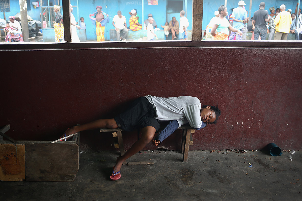 A girl whose father died earlier in the morning lies sick in the West Point slum