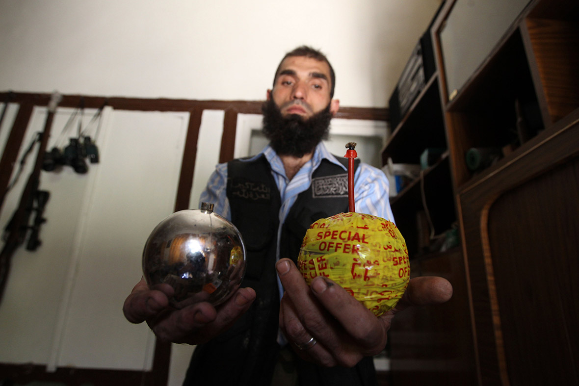 A Free Syrian Army fighter displays homemade bombs made from ornamental Christmas balls in Aleppo