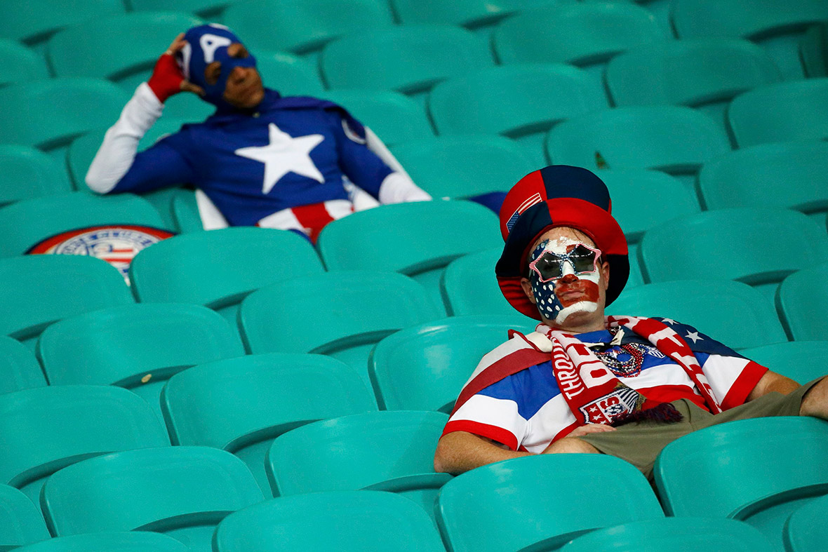 A fan dressed as Captain America (back) looks dejected at the end of extra time of the 2014 World Cup round of 16 game between US and Belgium at the Fonte Nova arena in Salvador
