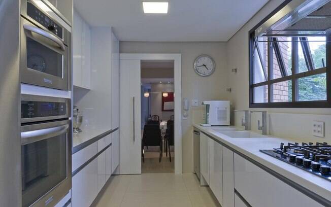Eletrodomésticos embutidos e porta de correr na divisão da sala foram as soluções da arquiteta Cynthia Pimentel Duarte para esta cozinha de 12 m2 